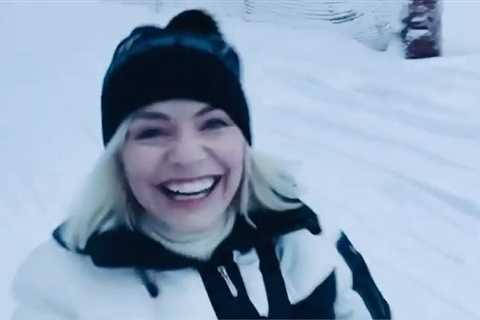 Holly Willoughby grins as she toboggans in the snow on holiday before Dancing on Ice launch