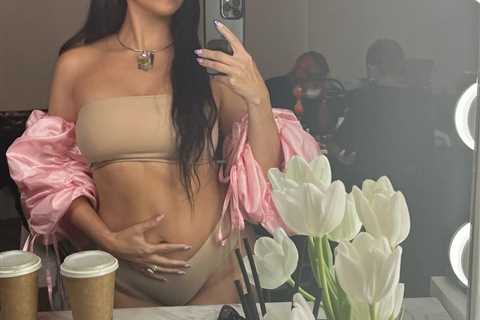 Kourtney Kardashian reveals if she’s pregnant with Travis Barker’s baby after cradling her stomach..